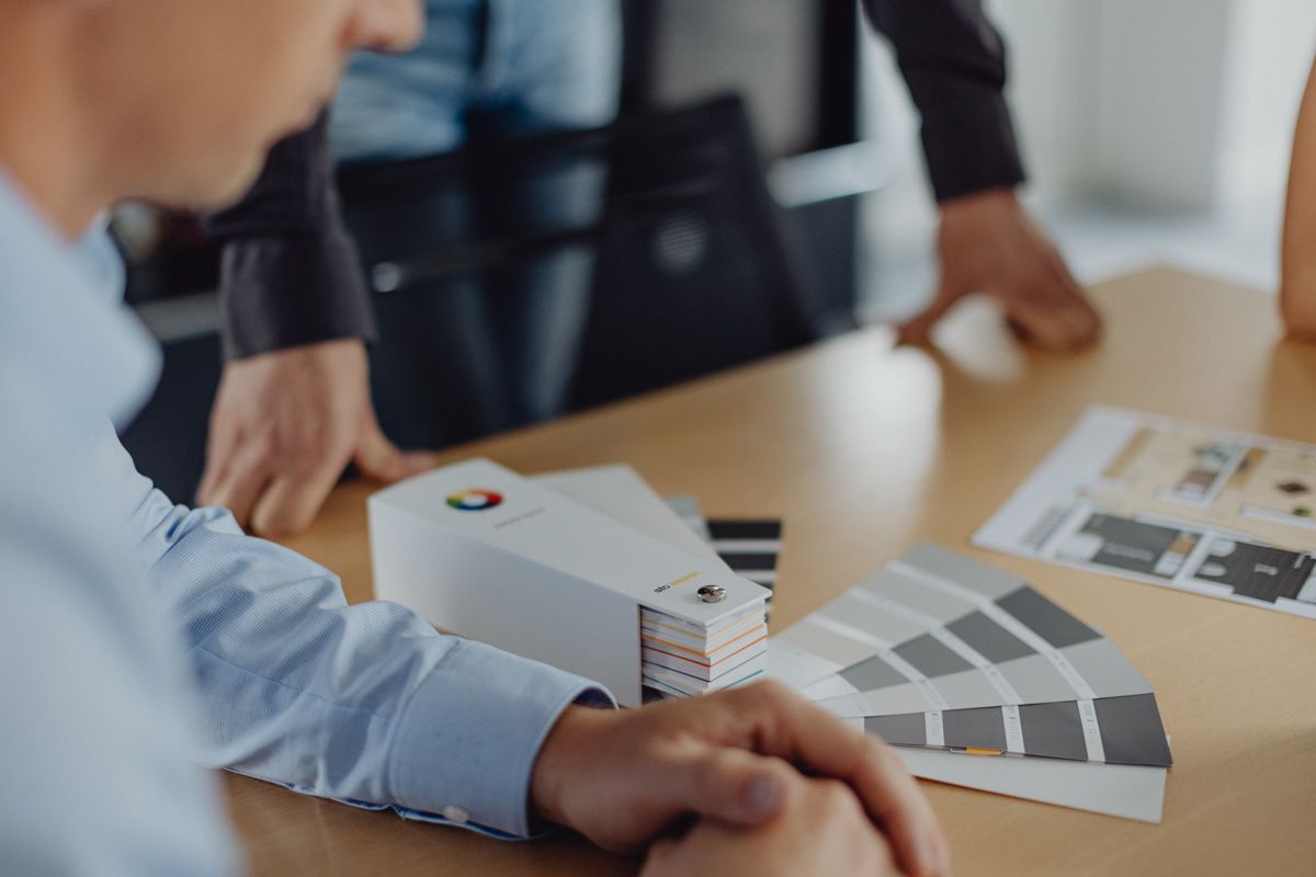 Farb- und Materialauswahl bei Bau- oder Einrichtungsplanung – Farbfächer, Grundrisse und Beratung am Tisch