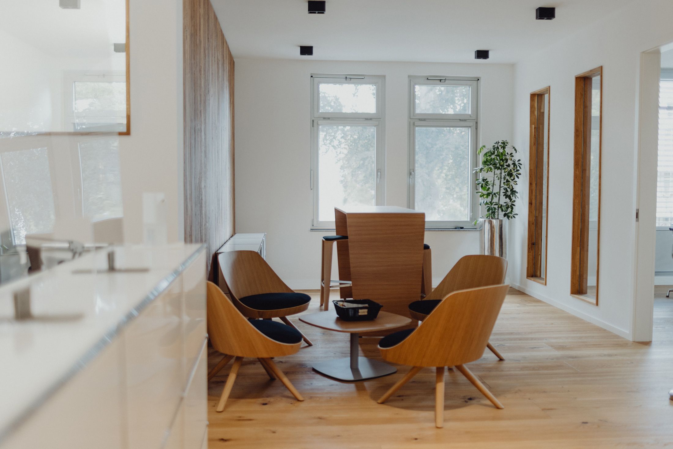 Moderner Besprechungsraum mit Designermöbeln, Holzoptik und viel Tageslicht – stilvolles Büroambiente